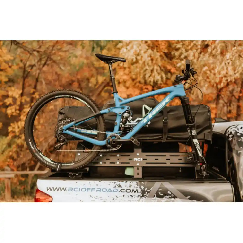 Bike mounted beside bed rack on a truck