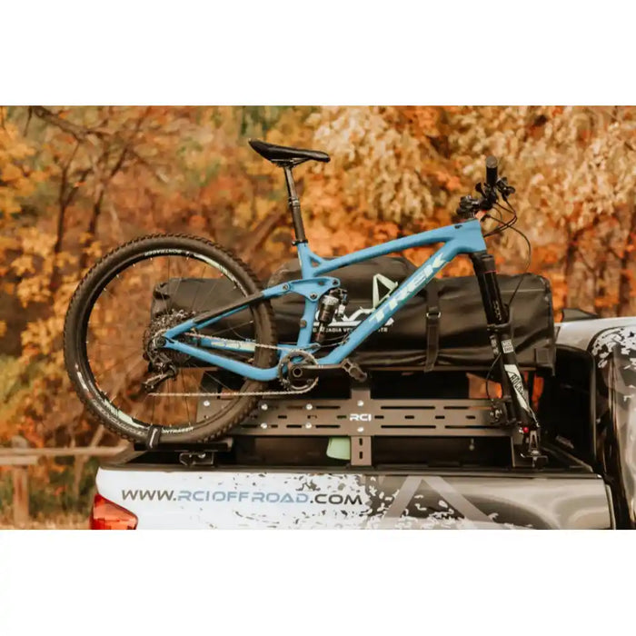 Bike mounted beside bed rack on a truck