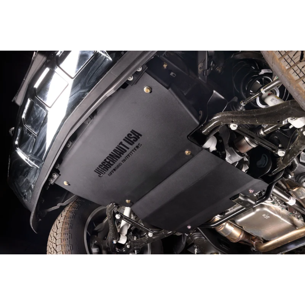 A black Underhill USA 2-Stage Exhaust Diverter installed on a vehicle undercarriage, shown next to the wheel well and exhaust system.