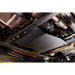 A black metal undercarriage shield plate installed on a vehicle's chassis, shown in a close-up view of the underside of a car.
