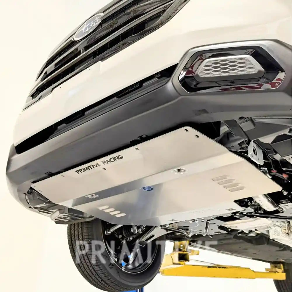 Close-up of a Primitive Forester undercarriage with a protective metal shield, branded 'Primitive Racing'.