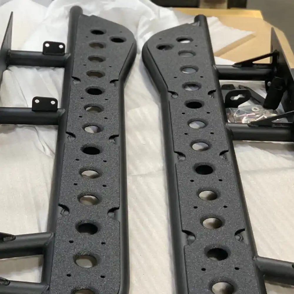 Two rock sliders with multiple holes on a white surface