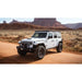 White Jeep Wrangler Rubicon with mounted Starlight roof rack on a desert road with desert landscape in the background
