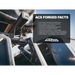 ACS Forged Tacoma bed rack system with 'ACS Forged Facts' card on a blurred background