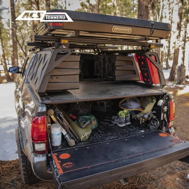 ACS Forged Tonneau bed rack with open cargo area and various items, featuring a tonneau cover Leitner Designs Bed Rack.