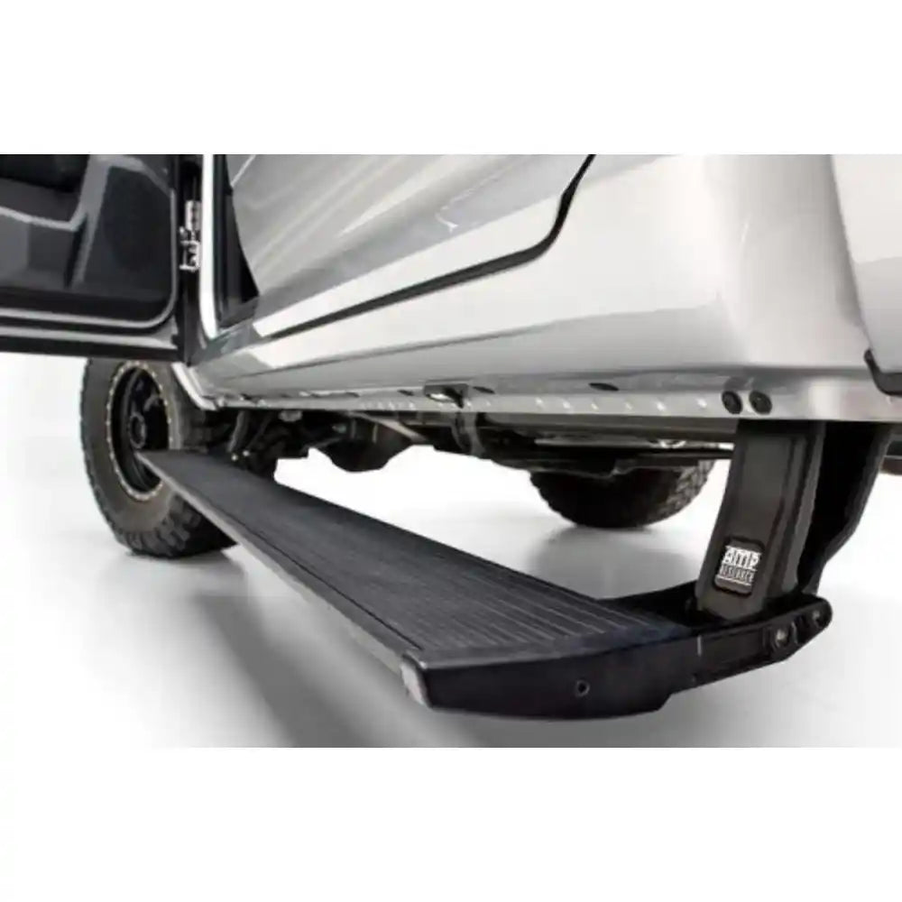 AMP Research PowerStep extended on a silver Ford F-150 with door open, showing the retractable running board in action.