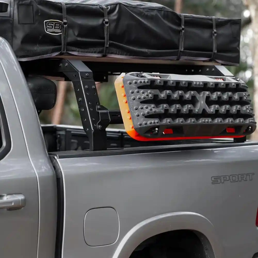 Bed Rack system on a truck bed with a black cover and orange and gray platform.