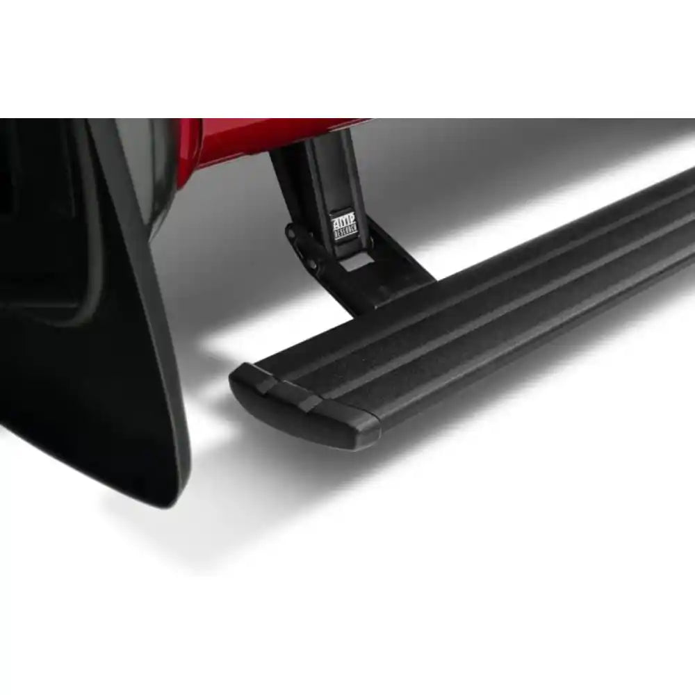 Black AMP Research PowerStep retractable running board deployed beneath a red Ford F-150 Raptor