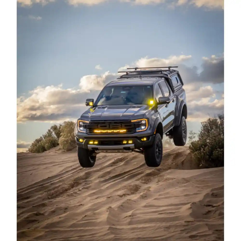 Black RCI Ranger speeding through sandy off-road terrain.