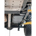 Black RCI fuel tank guard bolted in place under truck chassis, mid-rear perspective