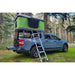 Blue Maverick with a green rooftop tent mounted on TUWA Pro Shiprock 4CX bed rack in a forest setting