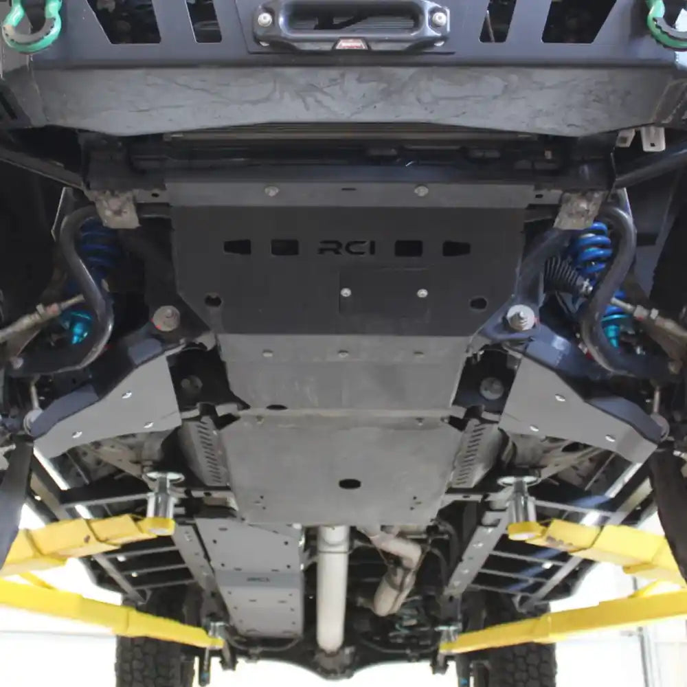 Blue coilovers visible behind installed RCI A-arm armor