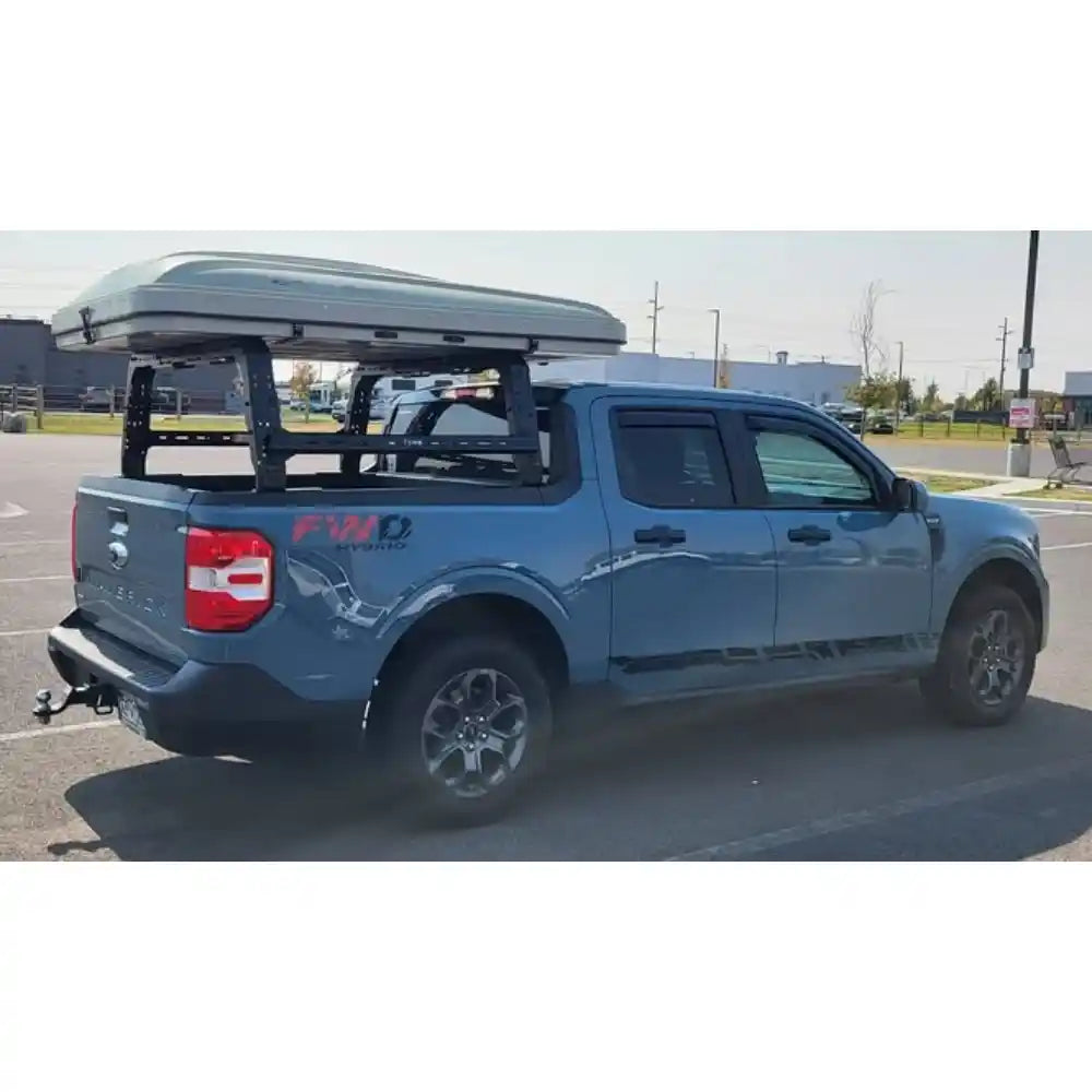 Blue ford truck with a bed rack and cargo bed cover in an outdoor setting