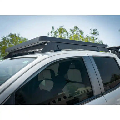 Canyon with a roof rack installed on a clear day with trees in the background