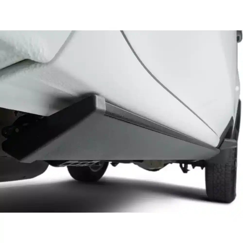 Close-up of AMP Research PowerStep Plug-N-Play on white Ram 1500 with illuminated blue lighting.