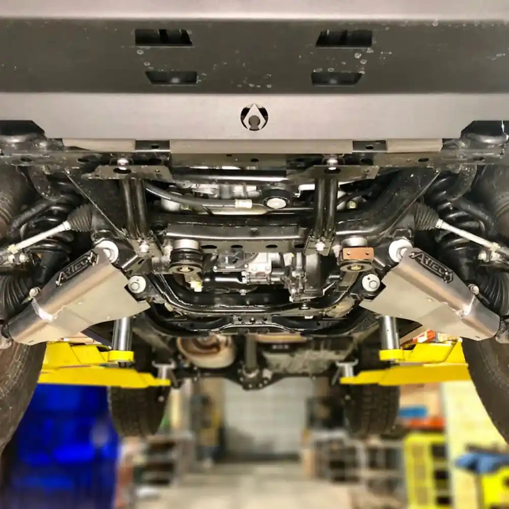 Close-up of a Tacoma's undercarriage with visible Lower control arm skid plates with Artec branding.