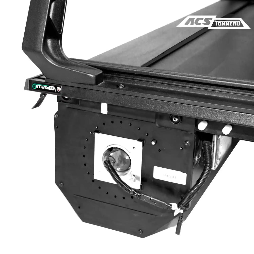 Close-up of a black Chevy bed cover with 'ACS Tonneauu' branding on a white background.