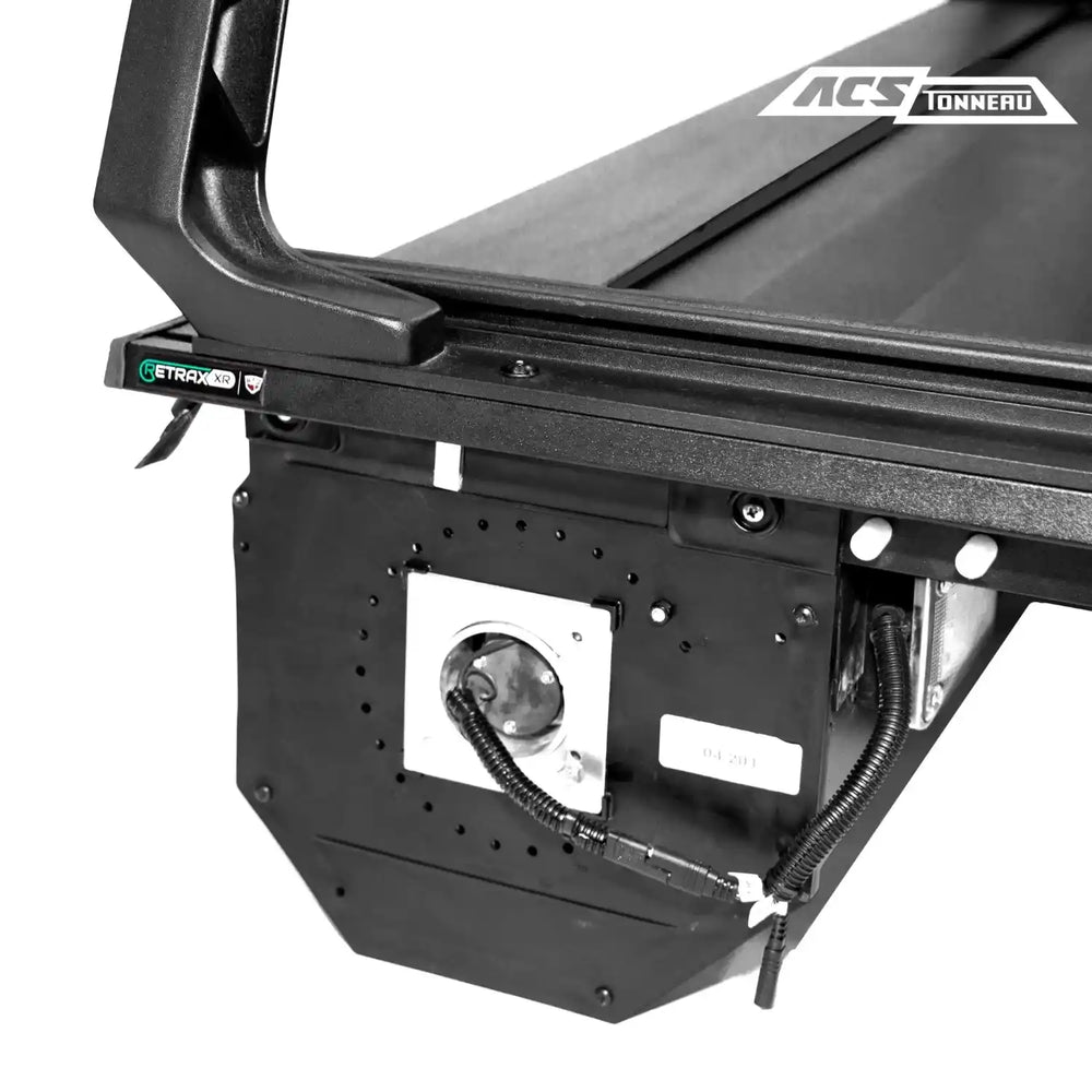 Close-up of a black truck bed tonneau cover with 'ACS Tonneau' branding on a white background.