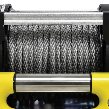 Close-up of a winch with coiled steel cable and yellow casing