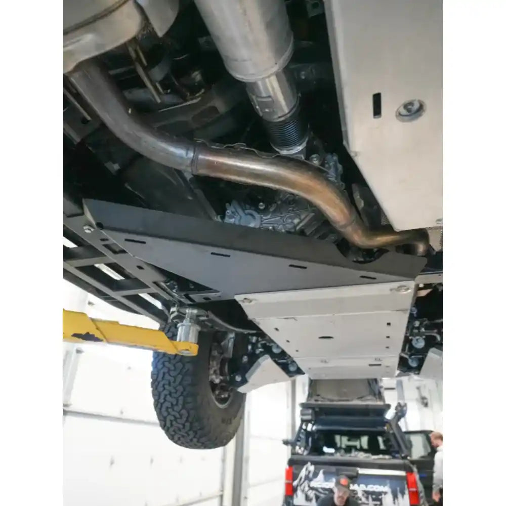 Close-up of installed RCI transfer case guard with exhaust routing visible