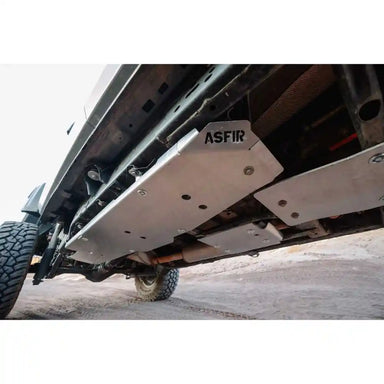 Close-up underside of Jeep Gladiator JT showing Asfir skid plates protecting the fuel tank and transfer case, with visible mounting bolts and clean fitment