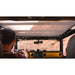 Person driving a wrangler with an open roof, looking out at a scenic landscape.