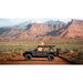 Side view of Sherpa rack on Black Jeep Wrangler on a dirt road with desert landscape and mountains in the background