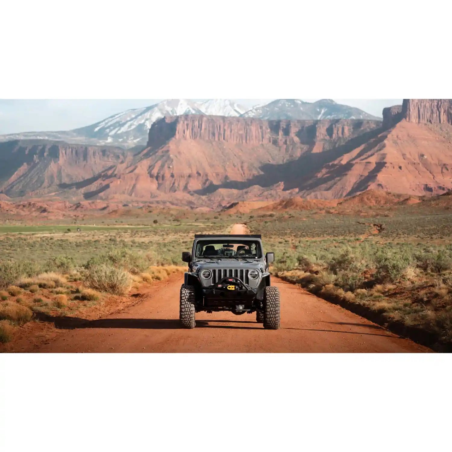 Front view of Sherpa roof rack mounted on Wrangler on an offroad with mountains in the back