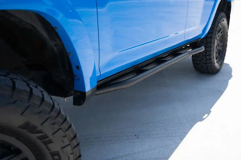 Close-up of a blue 4runner with trail edition sliders on a concrete surface