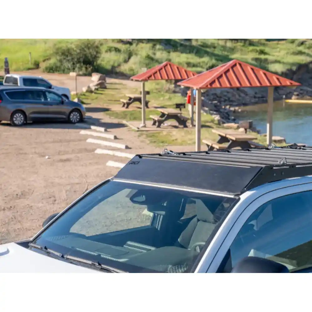 Detailed front-roof shot of white 4Runner showing RCI crossbars in sunny daylight