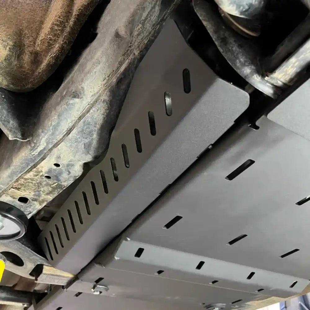 Detailed underside view of mounted RCI cat guard protecting catalytic converters