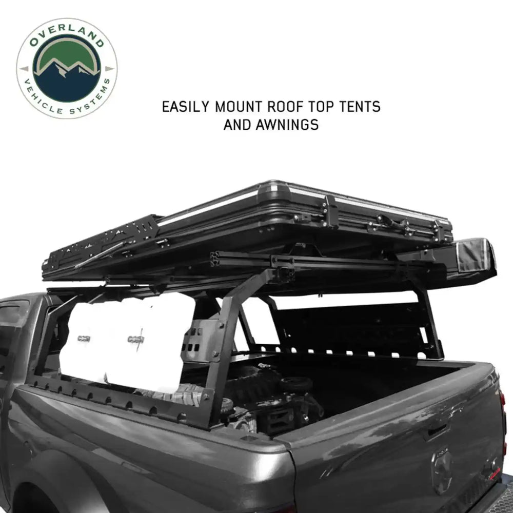 Truck bed with roof top tent and awning system on a white background, featuring Overland Vehicle Systems logo.
