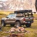 Toyota Tacoma truck with bed rack and camping gear in a mountainous landscape