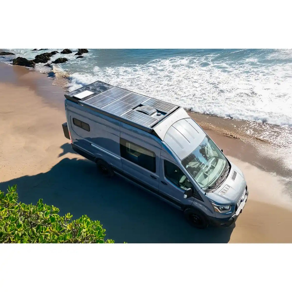 Camper van with solar panels on a beach near the ocean
