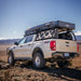 Ford truck with a bed rack and cargo box in a desert landscape.