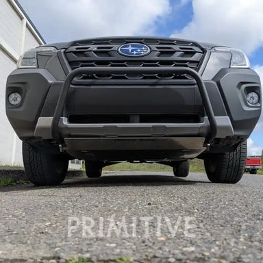 Front view of a gray Subaru truck with a visible grille and lip guard, parked on a paved surface.