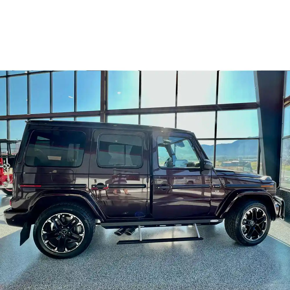 Full side profile of maroon G-Class showing rock slider protection