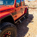 Full side profile of orange Jeep Gladiator with Rock Slide step sliders installed