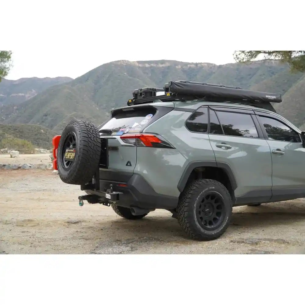 Gray SUV with tire rack and spare tire in mountainous area