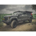 Gray ford with fully loaded Active cargo system on a dirt road with a cloudy sky