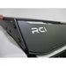 Hand pointing to RCI-branded rear fairing on black roof rack edge atop white Land Cruiser