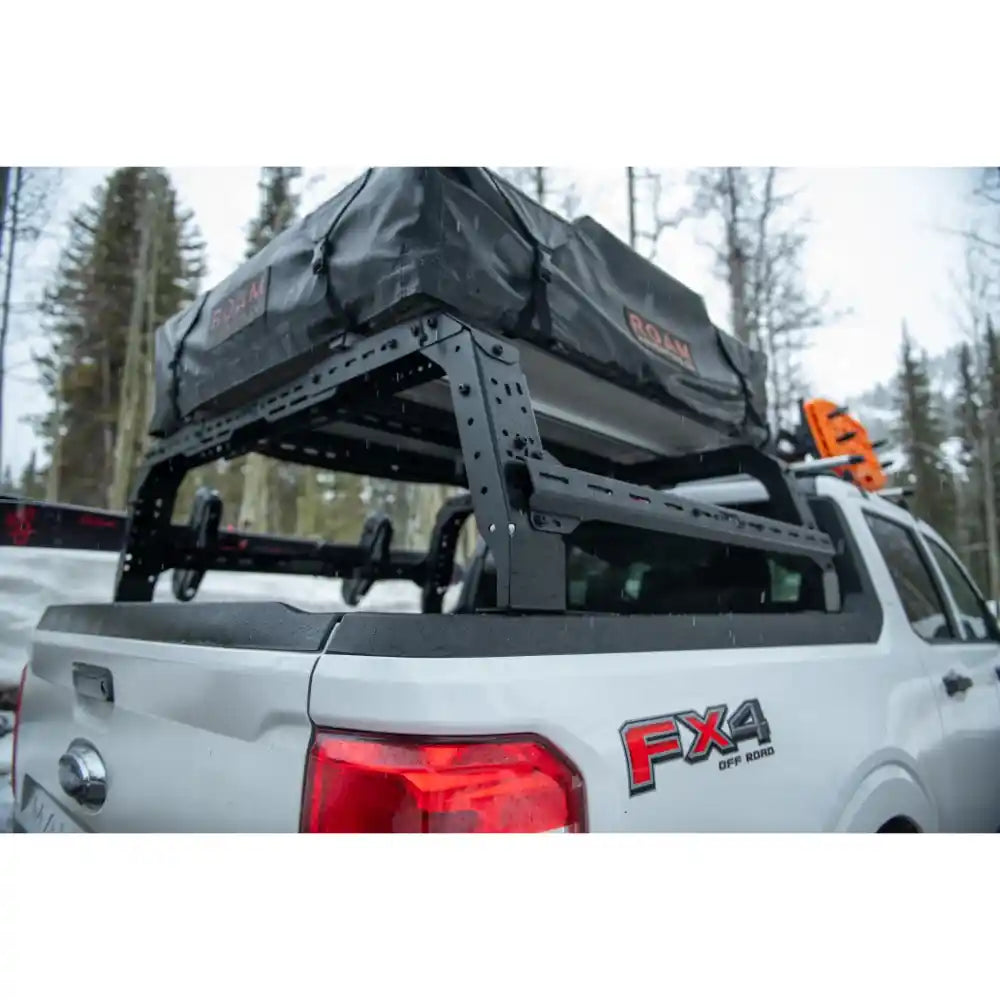 Height Adjustable Bed rack system on a white Ford with FX4 branding in a forest setting