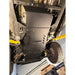 A black metal undercarriage shield with the brand name 'JUGhead' printed on it, installed on a vehicle lift in a garage.