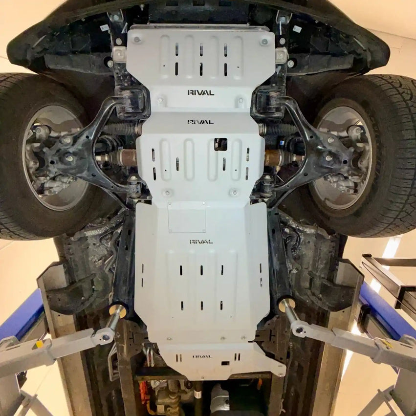 Full underbody skid plate system on Ford F-150 — RIVAL aluminum engine skid plate installed, showing complete undercarriage armor coverage