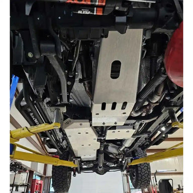 Jeep Gladiator JT off-roading with Asfir 3-piece skid plates installed, climbing rocky terrain.