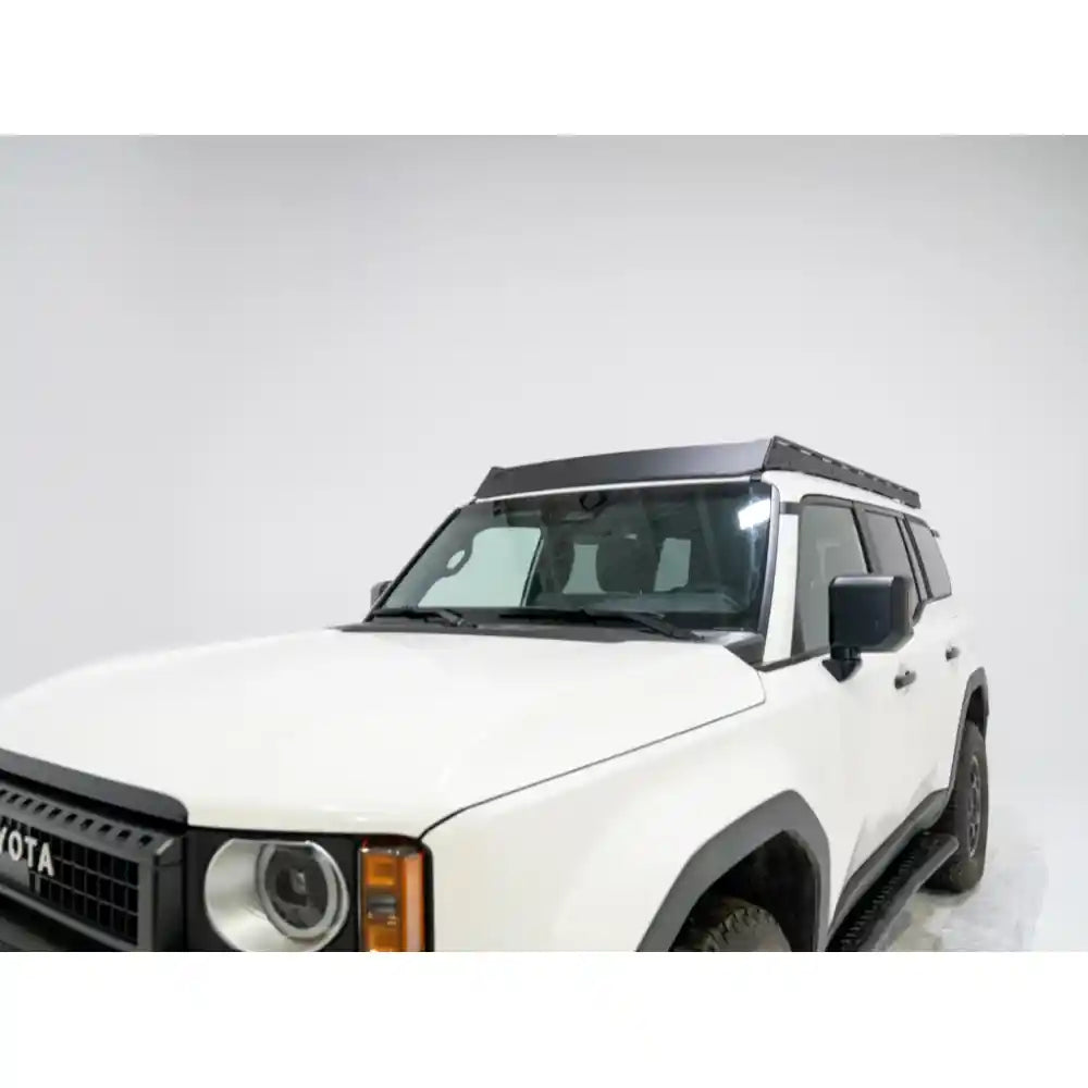 Low-angle view of black RCI roof rack on white Land Cruiser emphasizing sturdy aluminum construction