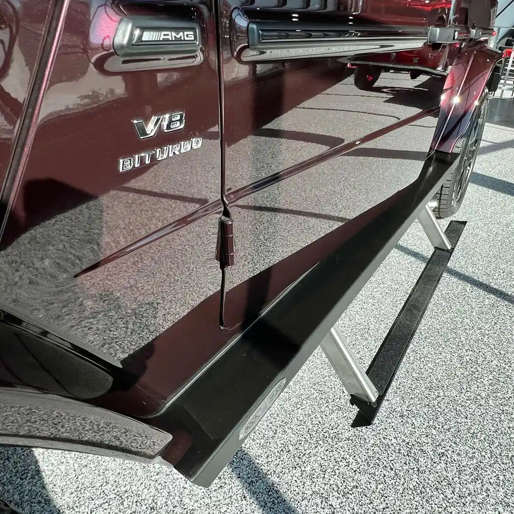 Maroon G-Wagon parked indoors with prominent black rock sliders