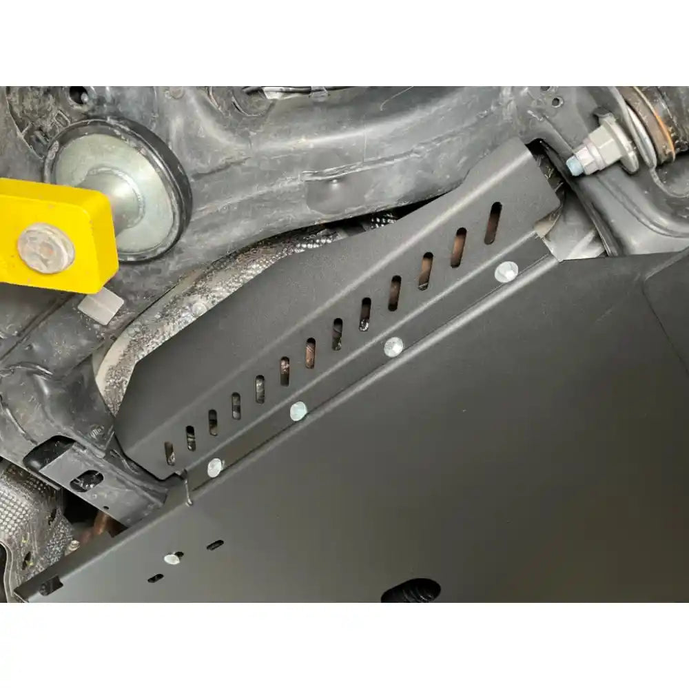 Matte black RCI catalytic guard bolted in place under Jeep