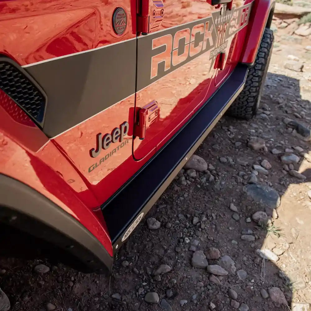 Orange Gladiator JT in rocky desert with prominent black rock sliders