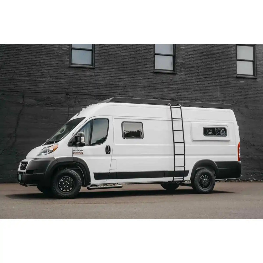 White van with black accents parked in front of a brick wall